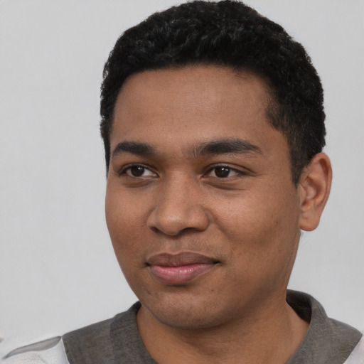Joyful black young-adult male with short  black hair and brown eyes