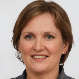 Joyful white adult female with medium  brown hair and grey eyes