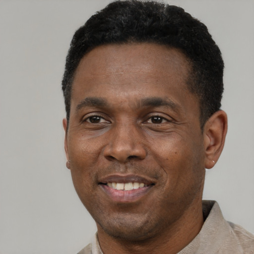 Joyful black adult male with short  black hair and brown eyes