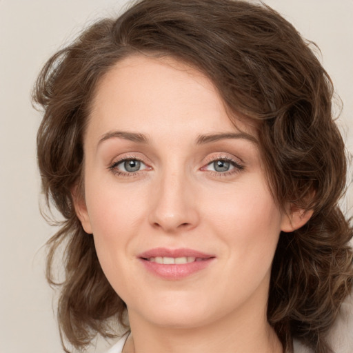 Joyful white young-adult female with medium  brown hair and green eyes