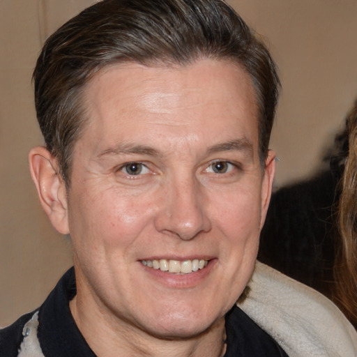 Joyful white adult male with medium  brown hair and brown eyes