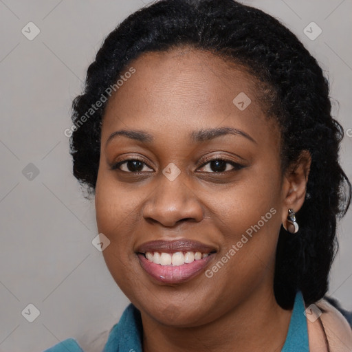 Joyful black young-adult female with long  black hair and brown eyes