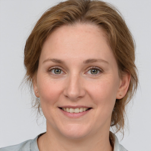 Joyful white adult female with medium  brown hair and blue eyes