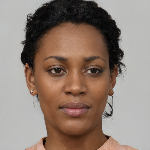 Joyful black young-adult female with short  black hair and brown eyes