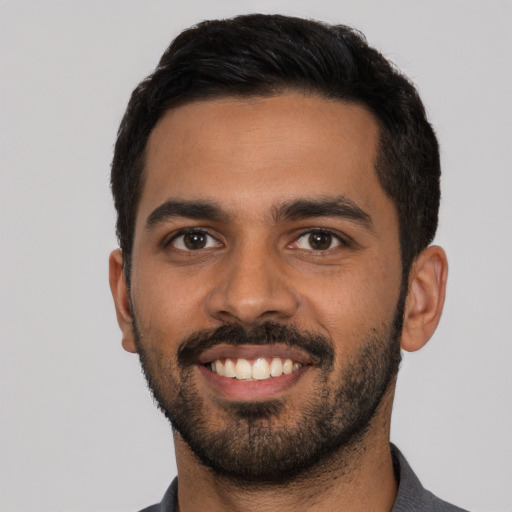 Joyful latino young-adult male with short  black hair and brown eyes