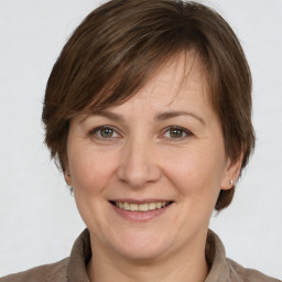 Joyful white adult female with medium  brown hair and grey eyes