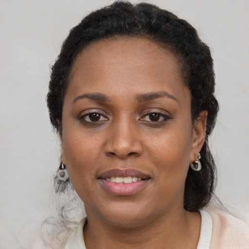 Joyful black young-adult female with short  brown hair and brown eyes