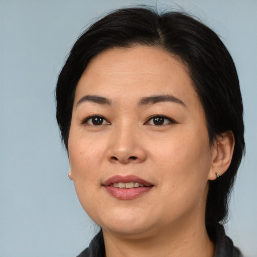 Joyful asian adult female with medium  black hair and brown eyes