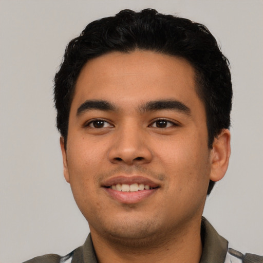 Joyful latino young-adult male with short  black hair and brown eyes