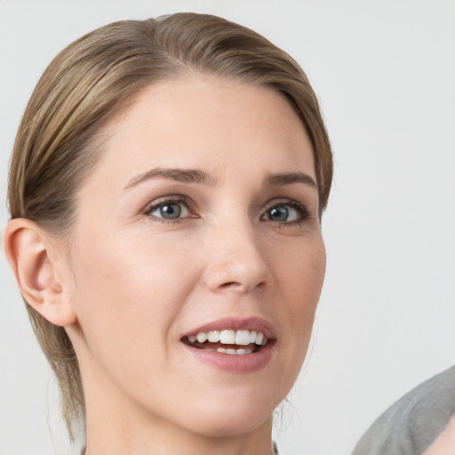 Joyful white young-adult female with medium  brown hair and grey eyes