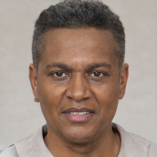Joyful black adult male with short  black hair and brown eyes