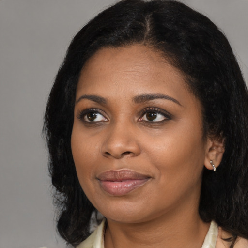Joyful black young-adult female with medium  black hair and brown eyes