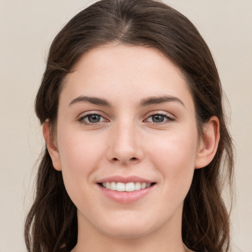 Joyful white young-adult female with long  brown hair and grey eyes