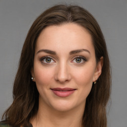 Joyful white young-adult female with long  brown hair and green eyes