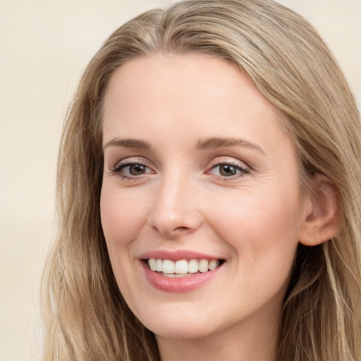 Joyful white young-adult female with long  brown hair and blue eyes