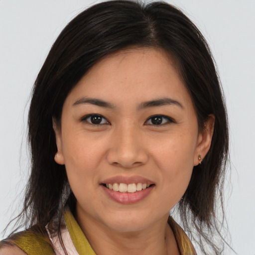 Joyful latino young-adult female with medium  brown hair and brown eyes
