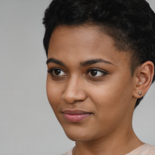 Joyful black young-adult female with short  brown hair and brown eyes