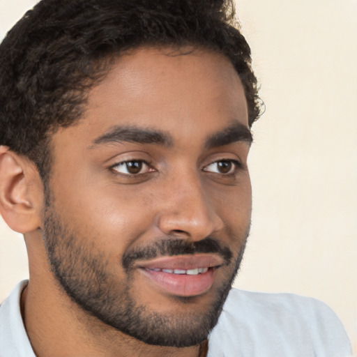 Joyful black young-adult male with short  brown hair and brown eyes