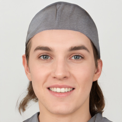 Joyful white young-adult male with medium  brown hair and grey eyes