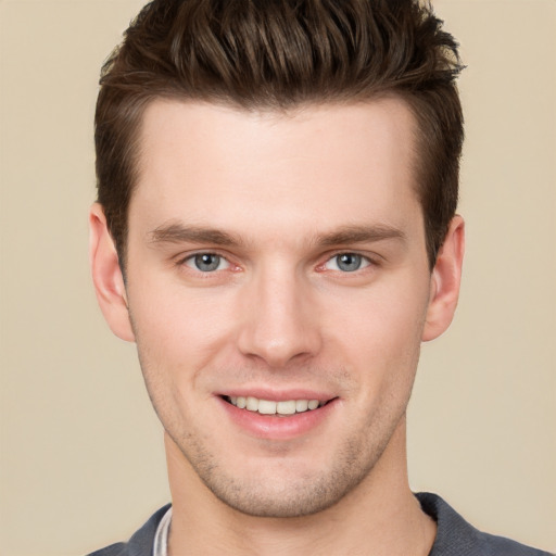 Joyful white young-adult male with short  brown hair and grey eyes