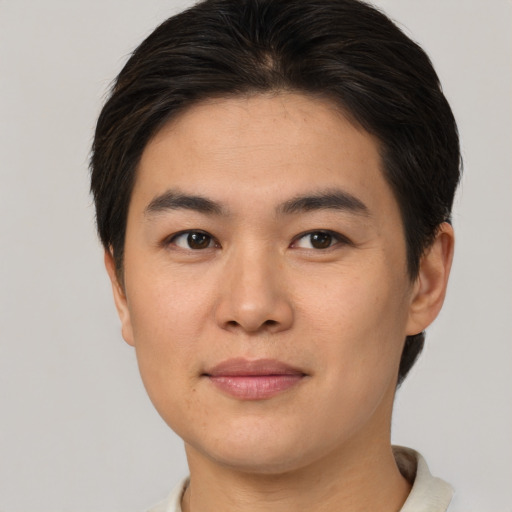 Joyful asian young-adult male with short  brown hair and brown eyes