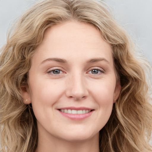 Joyful white young-adult female with long  brown hair and blue eyes