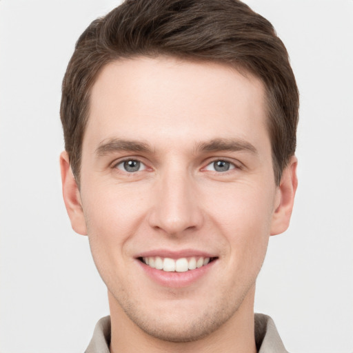 Joyful white young-adult male with short  brown hair and grey eyes