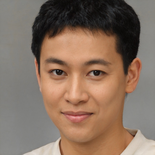 Joyful latino young-adult male with short  black hair and brown eyes