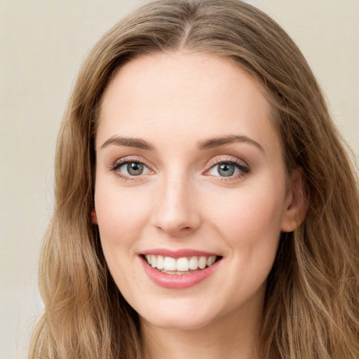 Joyful white young-adult female with long  brown hair and green eyes