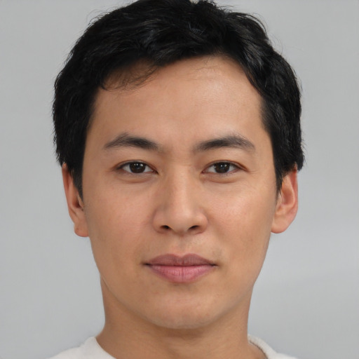 Joyful asian young-adult male with short  brown hair and brown eyes