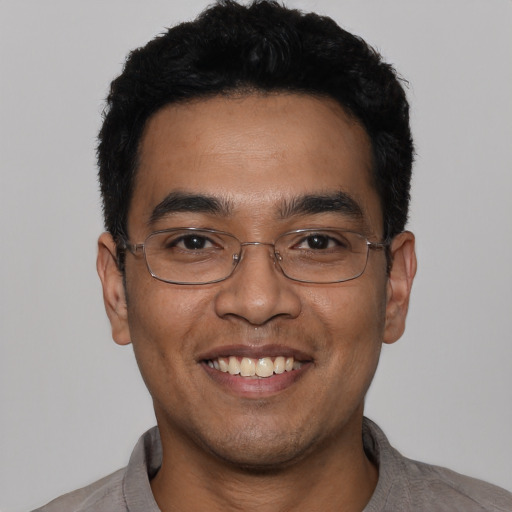 Joyful latino young-adult male with short  black hair and brown eyes