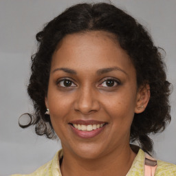 Joyful black young-adult female with medium  brown hair and brown eyes