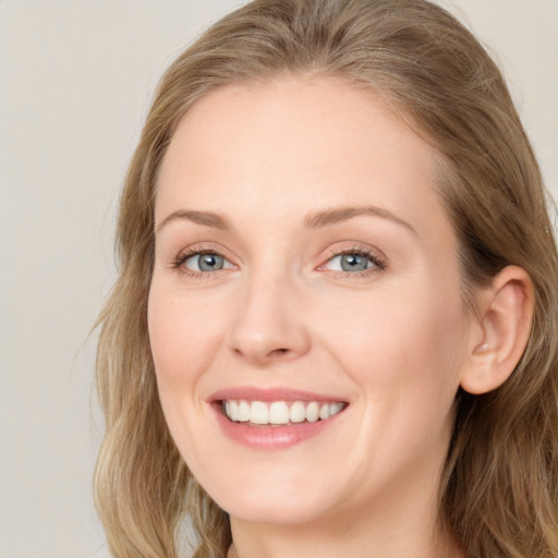 Joyful white young-adult female with long  brown hair and blue eyes