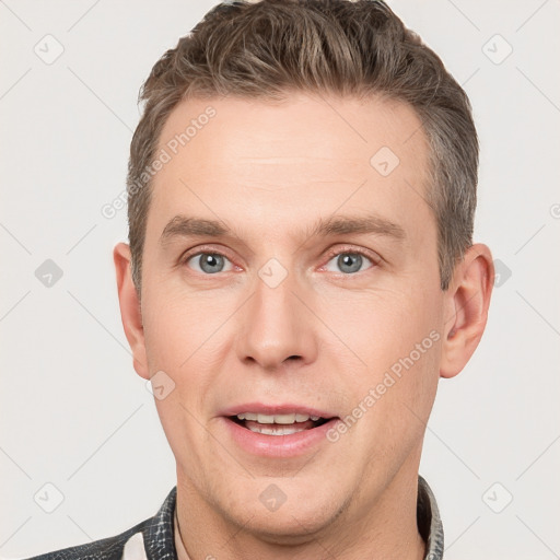 Joyful white adult male with short  brown hair and grey eyes