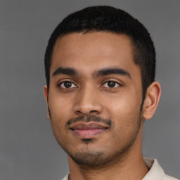 Joyful latino young-adult male with short  black hair and brown eyes