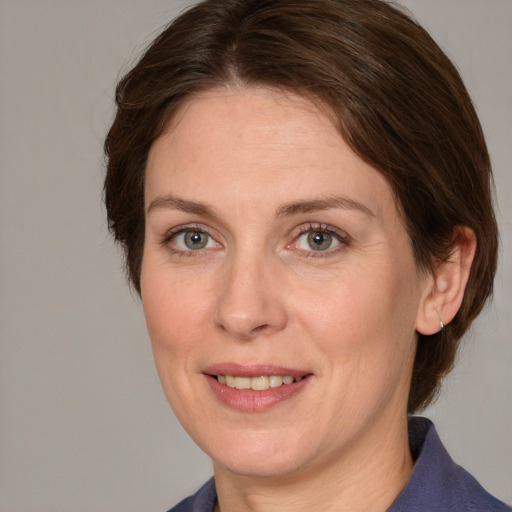 Joyful white adult female with medium  brown hair and grey eyes