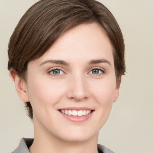 Joyful white young-adult female with short  brown hair and grey eyes