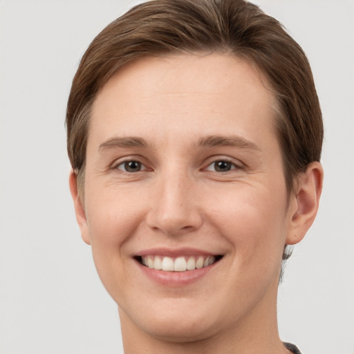 Joyful white young-adult female with short  brown hair and grey eyes