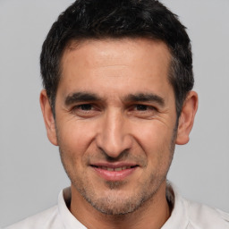 Joyful white adult male with short  black hair and brown eyes