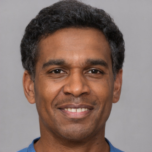Joyful latino adult male with short  black hair and brown eyes