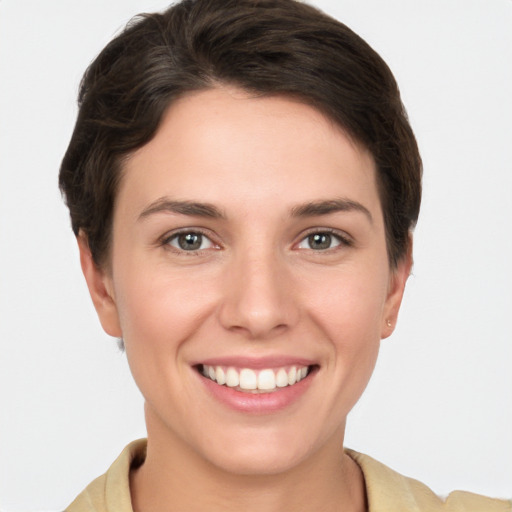 Joyful white young-adult female with short  brown hair and grey eyes