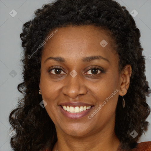 Joyful black young-adult female with long  brown hair and brown eyes