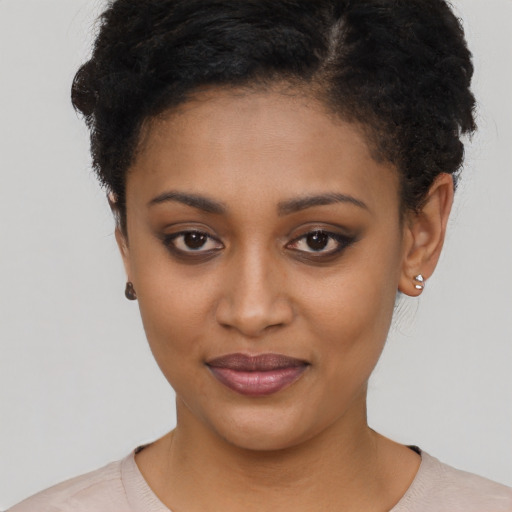 Joyful black young-adult female with short  brown hair and brown eyes
