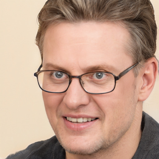 Joyful white adult male with short  brown hair and blue eyes