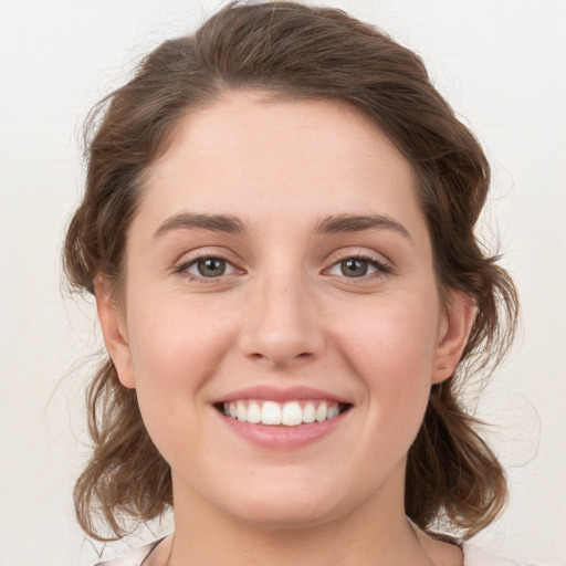 Joyful white young-adult female with medium  brown hair and green eyes