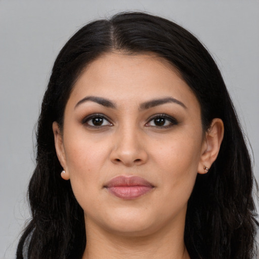 Joyful latino young-adult female with long  brown hair and brown eyes