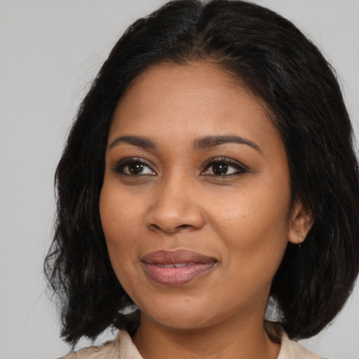 Joyful black young-adult female with medium  brown hair and brown eyes