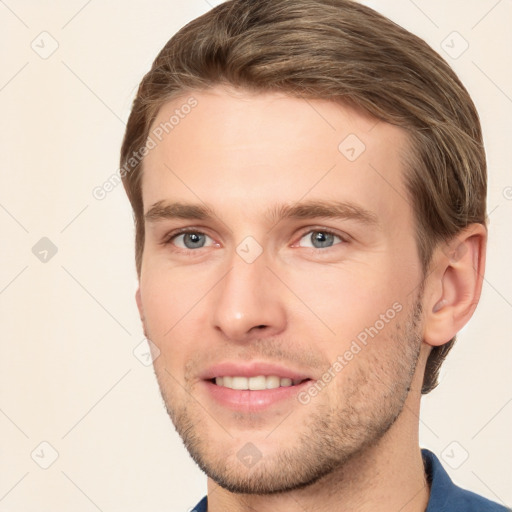 Joyful white young-adult male with short  brown hair and grey eyes