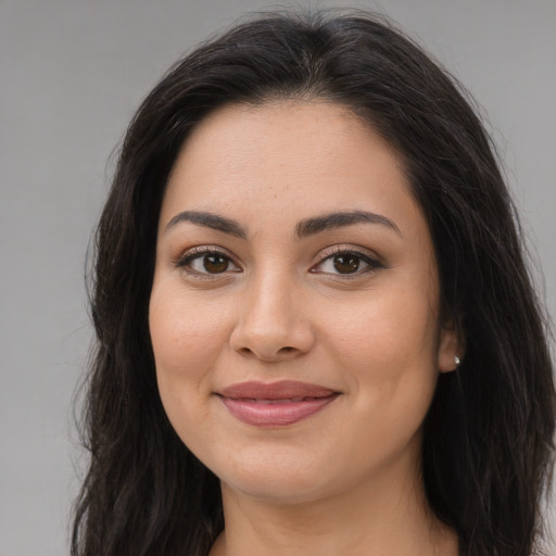 Joyful latino young-adult female with long  brown hair and brown eyes