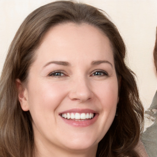 Joyful white young-adult female with long  brown hair and grey eyes